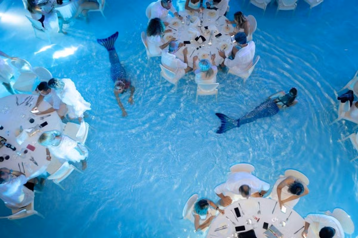Jantar dentro de piscina com 'sereia' entre mesas viraliza e rende piadas no Brasil; conheça